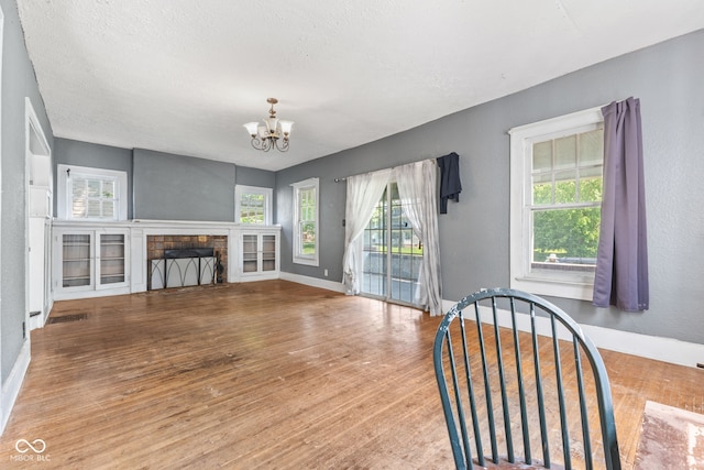3134 N College Ave, Indianapolis, IN 46205 - unfurnished living room featuring a chandelier, plenty of natural light, wood finished floors, and baseboards