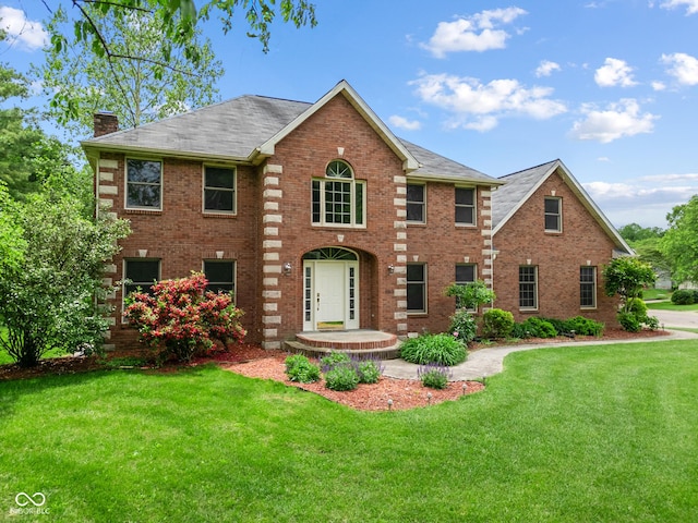 5313 Redbird Dr, Columbus, IN 47201 - view of front of property featuring a chimney, brick siding, and a front lawn