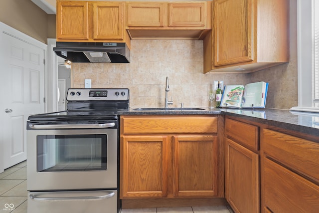 1720 Woodlawn Ave, Indianapolis, IN 46203 - kitchen featuring stainless steel electric range, under cabinet range hood, a sink, light tile patterned floors, and backsplash