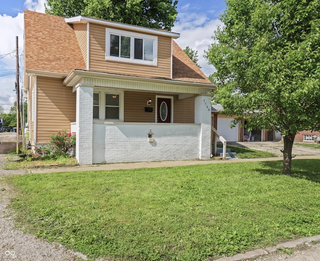 1720 Woodlawn Ave, Indianapolis, IN 46203 - view of front of property with a front lawn, brick siding, covered porch, an attached garage, and a shingled roof