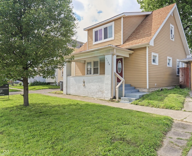 1720 Woodlawn Ave, Indianapolis, IN 46203 - bungalow-style house with a front lawn, a shingled roof, and brick siding