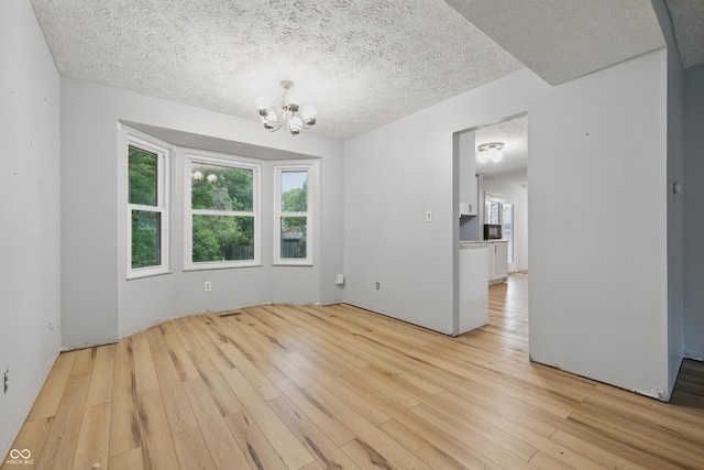 1826 Shorter Dr, Indianapolis, IN 46214 - spare room featuring light wood finished floors, a chandelier, and a textured ceiling