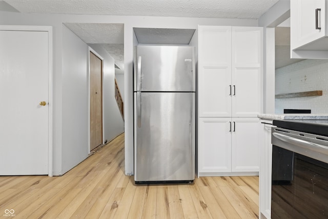 1826 Shorter Dr, Indianapolis, IN 46214 - kitchen featuring freestanding refrigerator, electric stove, light wood-style floors, white cabinets, and light countertops