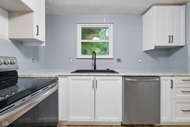 1826 Shorter Dr, Indianapolis, IN 46214 - kitchen with appliances with stainless steel finishes, a sink, a textured ceiling, and white cabinets