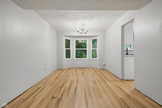 1826 Shorter Dr, Indianapolis, IN 46214 - unfurnished dining area with a chandelier, wood finished floors, a textured ceiling, and a sink