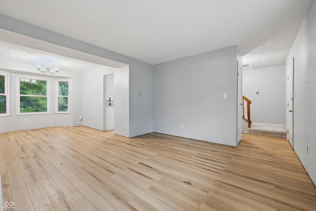 1826 Shorter Dr, Indianapolis, IN 46214 - spare room with a chandelier, light wood-type flooring, stairs, and a textured ceiling