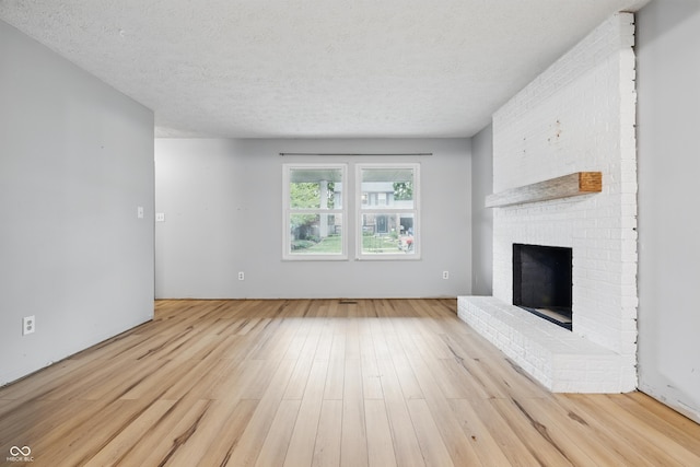 1826 Shorter Dr, Indianapolis, IN 46214 - unfurnished living room featuring a brick fireplace, wood finished floors, and a textured ceiling