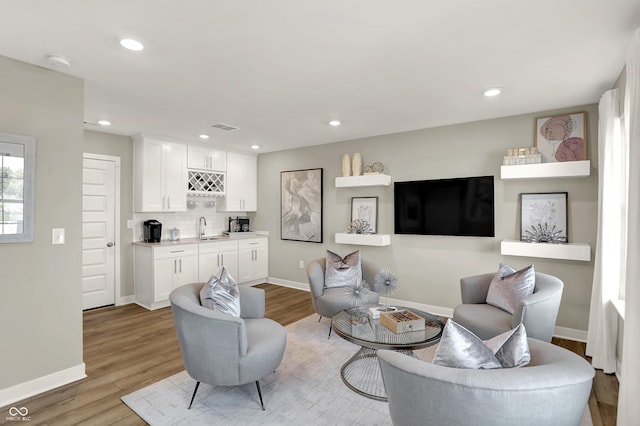 6702 Halsey St, Zionsville, IN 46077 - living room featuring bar with sink, light wood-style floors, baseboards, and recessed lighting