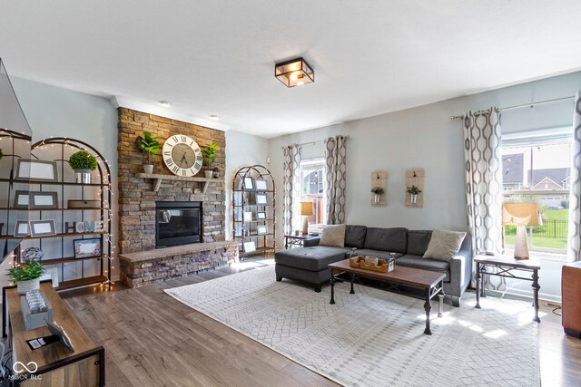 13485 Mancroft Dr, Fishers, IN 46037 - living room featuring wood finished floors, plenty of natural light, and a stone fireplace