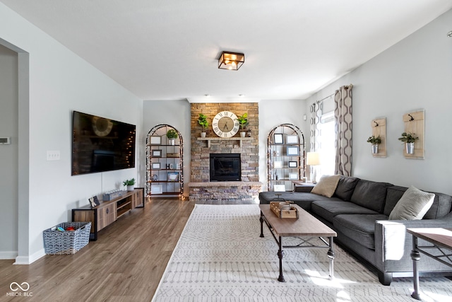 13485 Mancroft Dr, Fishers, IN 46037 - living room featuring wood finished floors, a stone fireplace, and baseboards