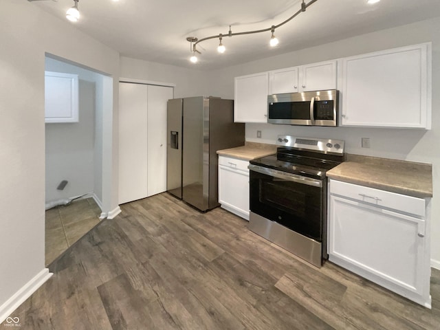 15110 Fawn Hollow Ln, Noblesville, IN 46060 - kitchen with appliances with stainless steel finishes, white cabinets, dark wood-style flooring, track lighting, and baseboards