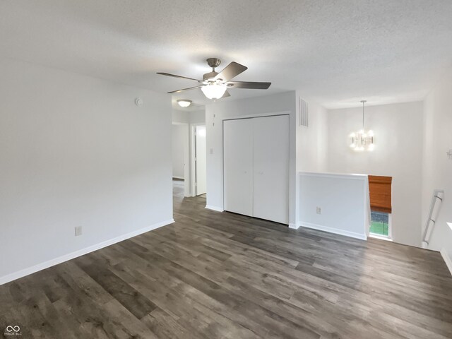 15110 Fawn Hollow Ln, Noblesville, IN 46060 - unfurnished living room featuring a ceiling fan, a chandelier, dark wood-style floors, a textured ceiling, and baseboards
