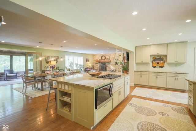 2034 Dubois Rd, Spencer, IN 47460 - kitchen featuring stainless steel appliances, recessed lighting, open floor plan, light wood-style floors, and light stone counters