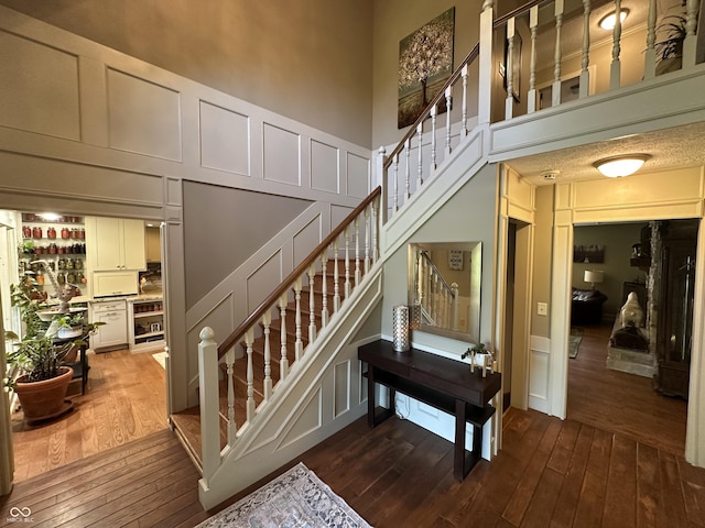 2034 Dubois Rd, Spencer, IN 47460 - staircase with a decorative wall, hardwood / wood-style floors, and a towering ceiling