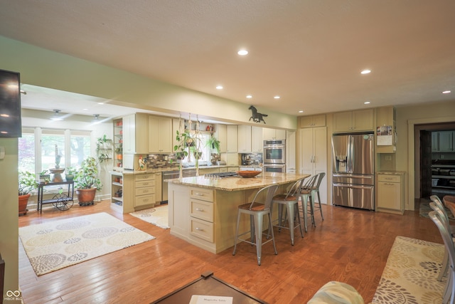 2034 Dubois Rd, Spencer, IN 47460 - kitchen with appliances with stainless steel finishes, a center island, light stone countertops, light wood-type flooring, and recessed lighting
