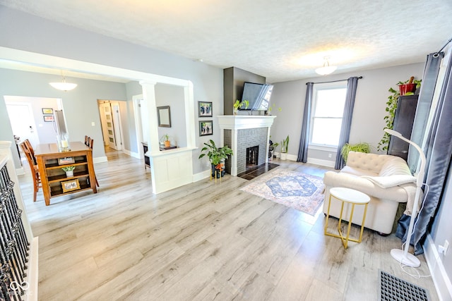 517 Bernard Ave, Indianapolis, IN 46208 - living room with light wood-type flooring, baseboards, a fireplace, and a textured ceiling