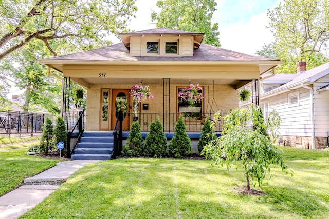 517 Bernard Ave, Indianapolis, IN 46208 - view of front facade with a porch, brick siding, and roof with shingles