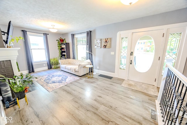 517 Bernard Ave, Indianapolis, IN 46208 - entryway with baseboards, wood finished floors, a textured ceiling, and a brick fireplace