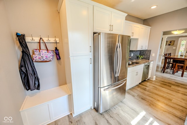 517 Bernard Ave, Indianapolis, IN 46208 - kitchen with appliances with stainless steel finishes, light wood-style floors, backsplash, white cabinets, and recessed lighting
