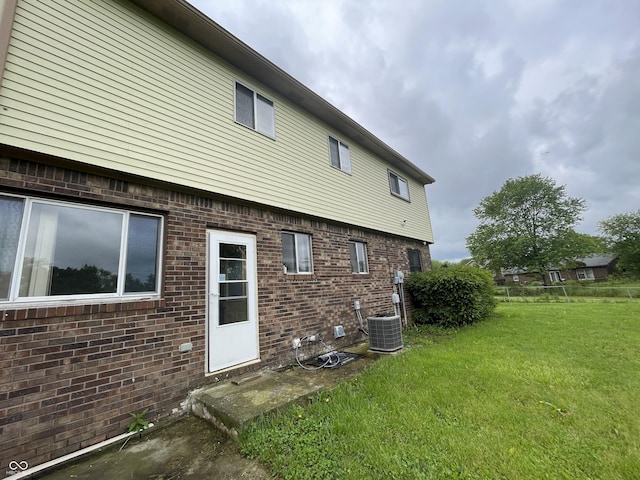 5760 Tim Tam Ct, Indianapolis, IN 46237 - rear view of house with a yard, brick siding, and central AC unit