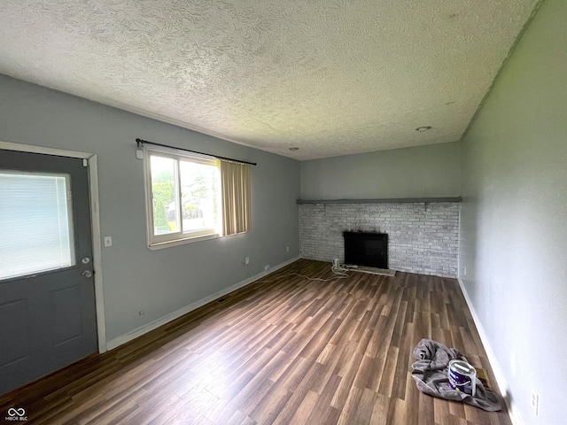 5760 Tim Tam Ct, Indianapolis, IN 46237 - unfurnished living room with a textured ceiling, a brick fireplace, wood finished floors, and baseboards