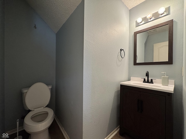 5502 Floating Leaf Dr, Indianapolis, IN 46237 - half bathroom with a textured ceiling, vanity, lofted ceiling, toilet, and baseboards