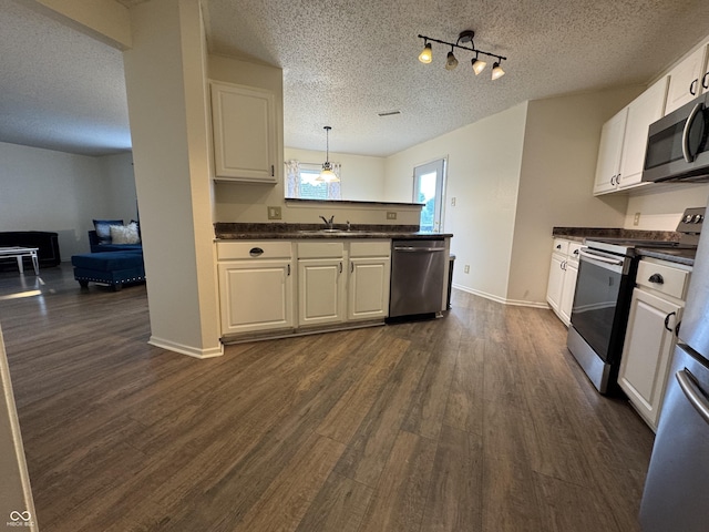 5502 Floating Leaf Dr, Indianapolis, IN 46237 - kitchen featuring stainless steel appliances, dark countertops, a textured ceiling, dark wood-style flooring, and white cabinetry