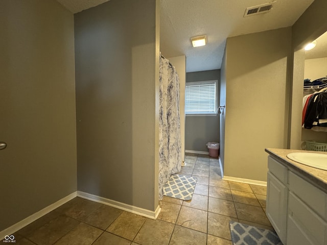 5502 Floating Leaf Dr, Indianapolis, IN 46237 - full bath featuring tile patterned flooring, vanity, a textured ceiling, a shower with shower curtain, and baseboards
