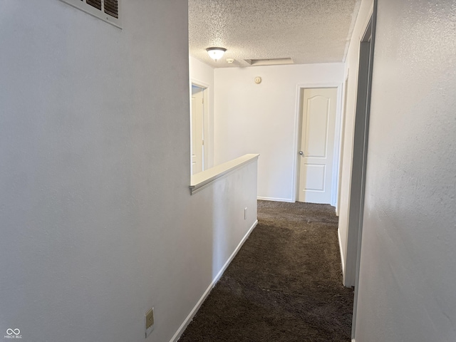 5502 Floating Leaf Dr, Indianapolis, IN 46237 - hallway with dark carpet, a textured ceiling, an upstairs landing, and baseboards
