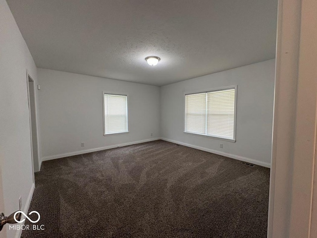 844 Ben Franklin St, Cloverdale, IN 46120 - spare room with baseboards, dark colored carpet, and a textured ceiling