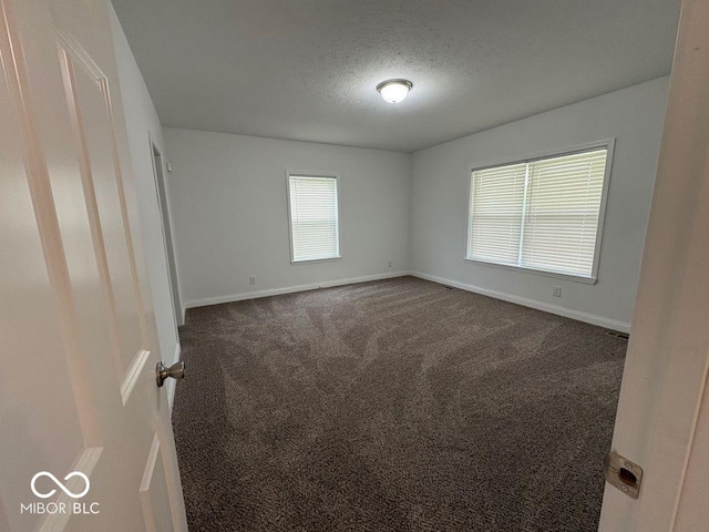 844 Ben Franklin St, Cloverdale, IN 46120 - unfurnished bedroom featuring baseboards, dark carpet, and a textured ceiling
