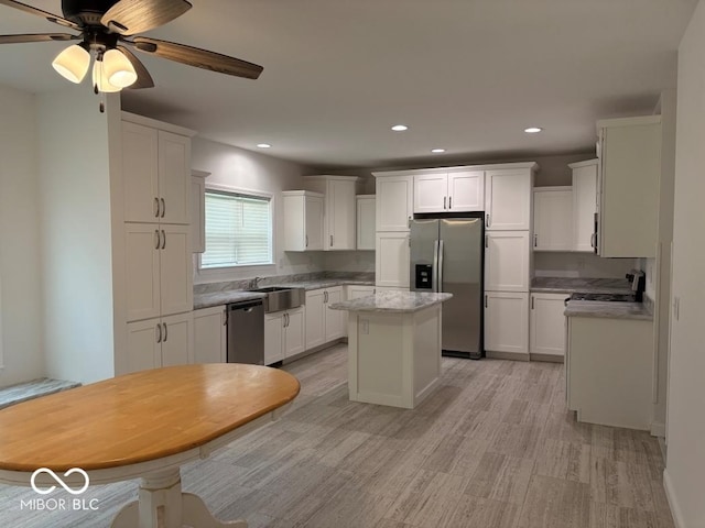 844 Ben Franklin St, Cloverdale, IN 46120 - kitchen with appliances with stainless steel finishes, light wood-type flooring, white cabinets, a kitchen island, and recessed lighting