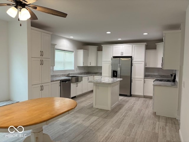 844 Ben Franklin St, Cloverdale, IN 46120 - kitchen with stainless steel appliances, a sink, light wood-type flooring, a kitchen island, and white cabinetry