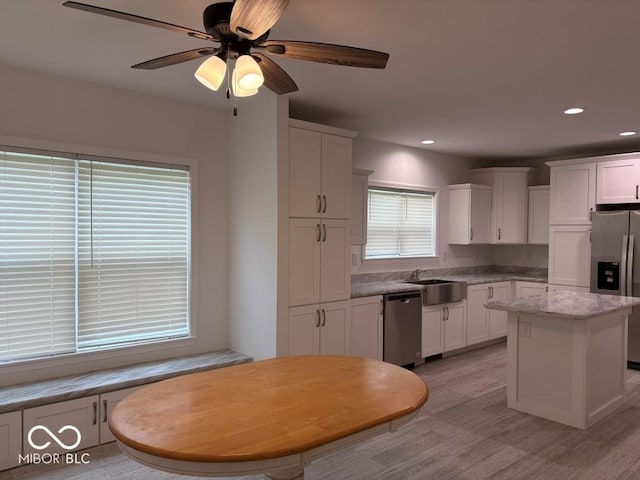 844 Ben Franklin St, Cloverdale, IN 46120 - kitchen featuring stainless steel appliances, a sink, white cabinets, light wood finished floors, and a center island