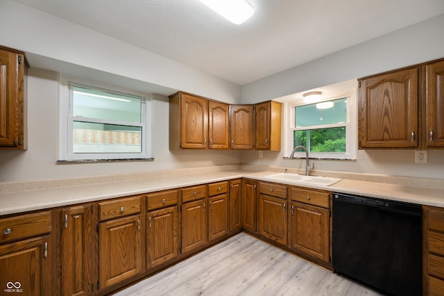 7482 W US Highway 40, Indianapolis, IN 46229 - kitchen with black dishwasher, a sink, light wood-style floors, and brown cabinetry