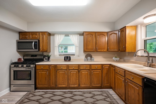 7482 W US Highway 40, Indianapolis, IN 46229 - kitchen featuring stainless steel appliances, a sink, brown cabinetry, and healthy amount of natural light