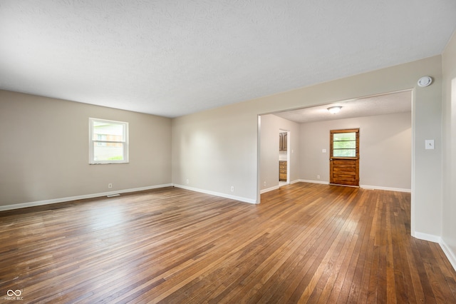 7482 W US Highway 40, Indianapolis, IN 46229 - spare room featuring hardwood / wood-style floors, plenty of natural light, baseboards, a smoke detector, and a textured ceiling