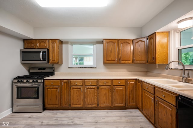7482 W US Highway 40, Indianapolis, IN 46229 - kitchen featuring appliances with stainless steel finishes, a sink, brown cabinets, and light wood-style floors