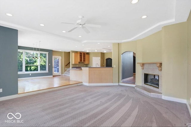 11575 Freeport Dr, Carmel, IN 46032 - unfurnished living room featuring light carpet, a tray ceiling, recessed lighting, a tiled fireplace, and baseboards