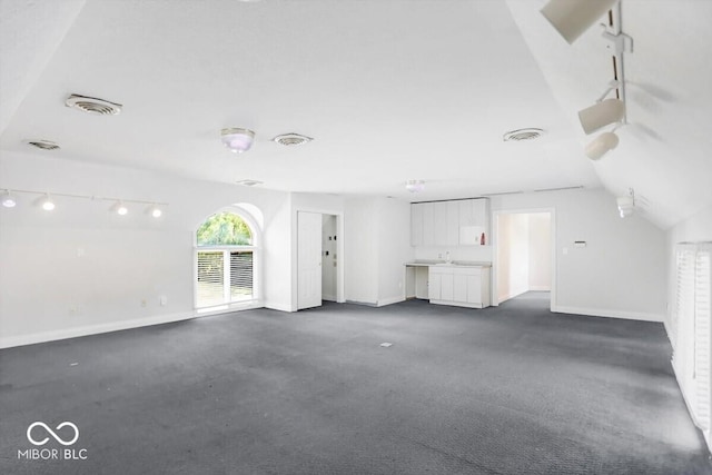 11575 Freeport Dr, Carmel, IN 46032 - unfurnished living room featuring lofted ceiling, baseboards, and dark colored carpet