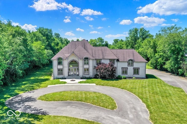 11575 Freeport Dr, Carmel, IN 46032 - french country inspired facade with curved driveway, french doors, a front lawn, stucco siding, and a shingled roof