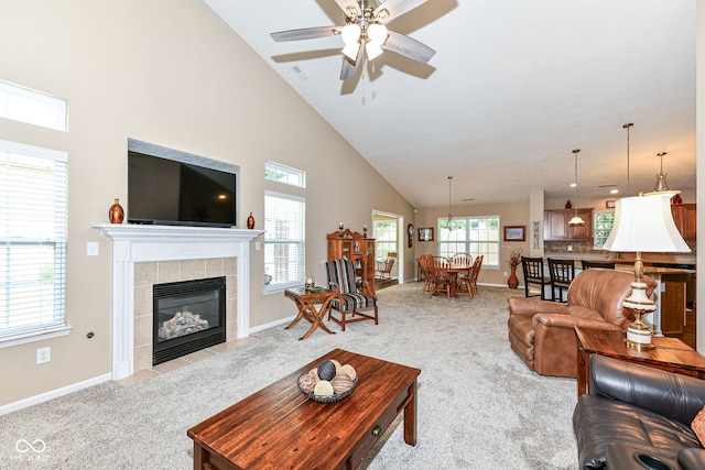 11692 Seven Oaks Dr, Fishers, IN 46038 - living area with light carpet, high vaulted ceiling, a ceiling fan, a tile fireplace, and baseboards