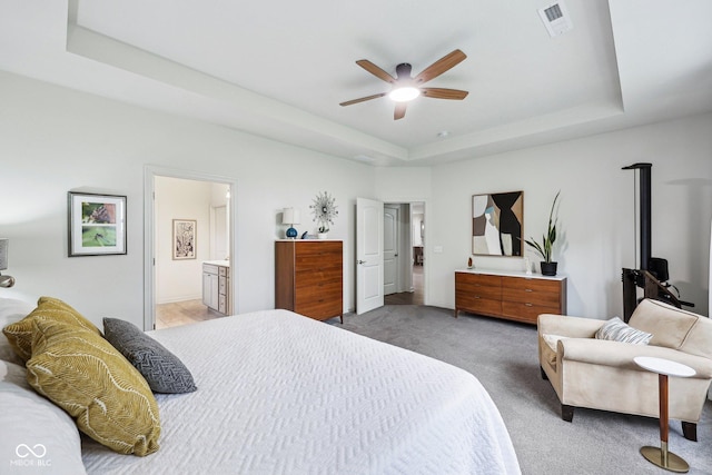 14458 Carlow Run, Carmel, IN 46074 - bedroom with a tray ceiling, light colored carpet, ensuite bathroom, ceiling fan, and baseboards
