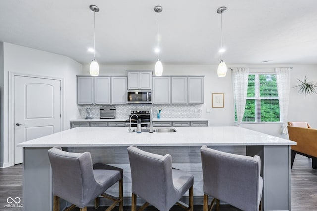 14458 Carlow Run, Carmel, IN 46074 - kitchen featuring stainless steel appliances, gray cabinetry, dark wood finished floors, and decorative backsplash