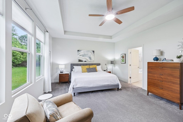 14458 Carlow Run, Carmel, IN 46074 - carpeted bedroom with a tray ceiling, baseboards, connected bathroom, and ceiling fan