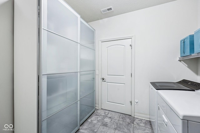 14458 Carlow Run, Carmel, IN 46074 - laundry room with washing machine and dryer and a textured ceiling