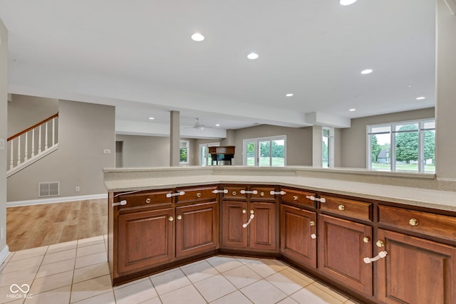 6610 Royal Oakland Dr, Indianapolis, IN 46236 - kitchen featuring light countertops, healthy amount of natural light, recessed lighting, light tile patterned floors, and brown cabinetry
