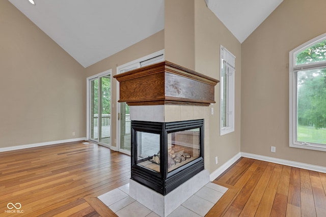 6610 Royal Oakland Dr, Indianapolis, IN 46236 - unfurnished living room with vaulted ceiling, a fireplace, light wood finished floors, healthy amount of natural light, and baseboards
