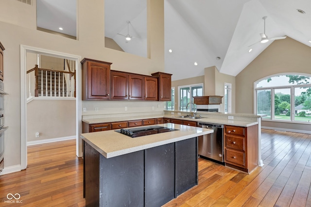 6610 Royal Oakland Dr, Indianapolis, IN 46236 - kitchen with stainless steel dishwasher, a peninsula, a sink, light countertops, and light wood-type flooring