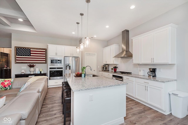 15593 Marsden Dr, Westfield, IN 46074 - kitchen featuring stainless steel appliances, wall chimney range hood, open floor plan, a breakfast bar area, and tasteful backsplash